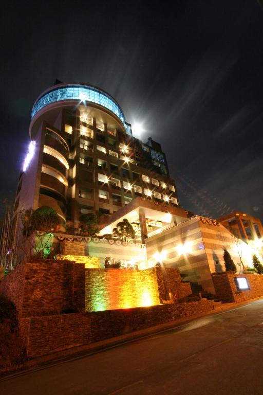 ein großes Gebäude, das nachts beleuchtet ist in der Unterkunft WIZ Hotel in Paju