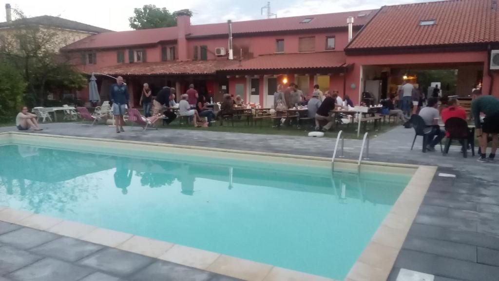 un grupo de personas sentadas alrededor de una piscina en Biogarden, en Zelarino