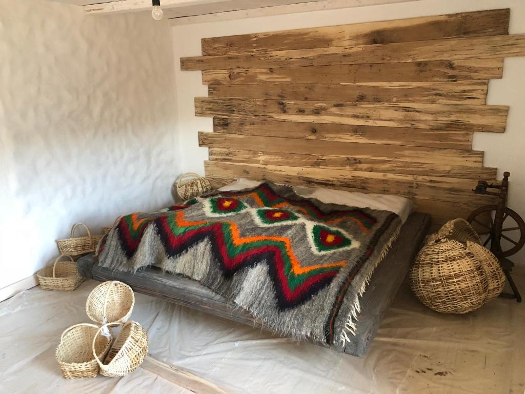 Bett in einem Zimmer mit einer Holzwand in der Unterkunft ГУЦУЛЬСЬКА ХАТА in Jassinja