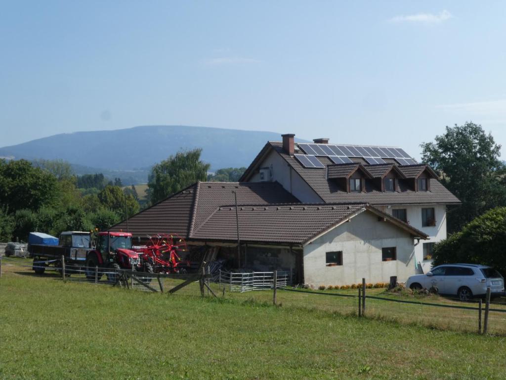 un granero con una casa con paneles solares. en Ubytování Farma U sv. Jakuba, en Dolní Lánov