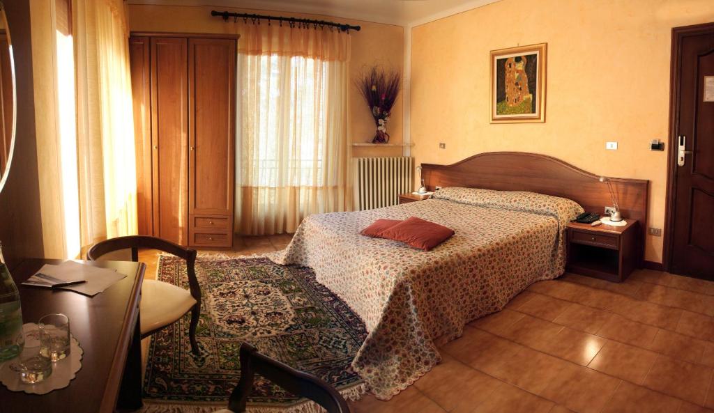 1 dormitorio con cama, mesa y ventana en Hotel Reale, en Lurisia