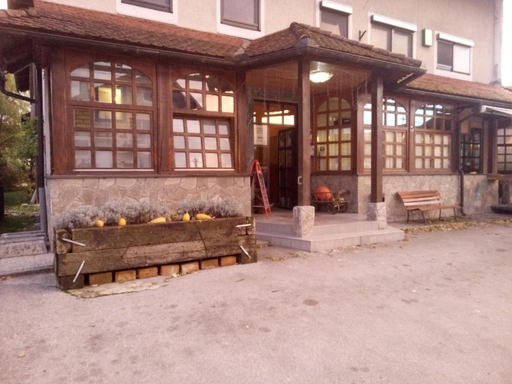 a building with a pavilion with a bench in front of it at Gostilna Ulčar in Ig