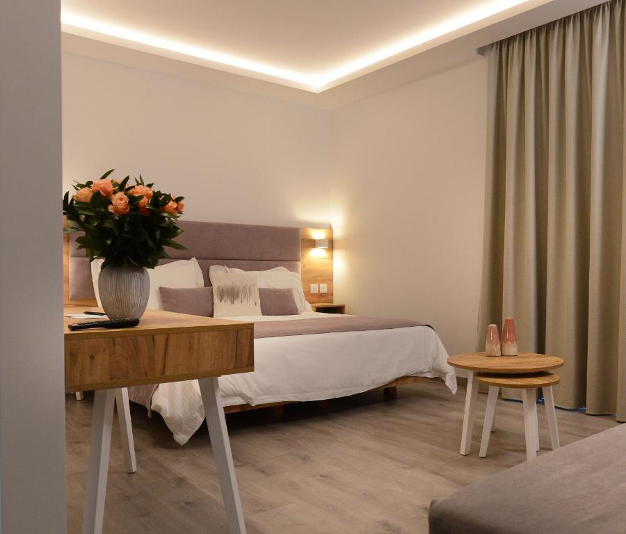 een slaapkamer met een bed en een vaas met bloemen op een tafel bij Hypnos Boutique Hotel in Nicosia