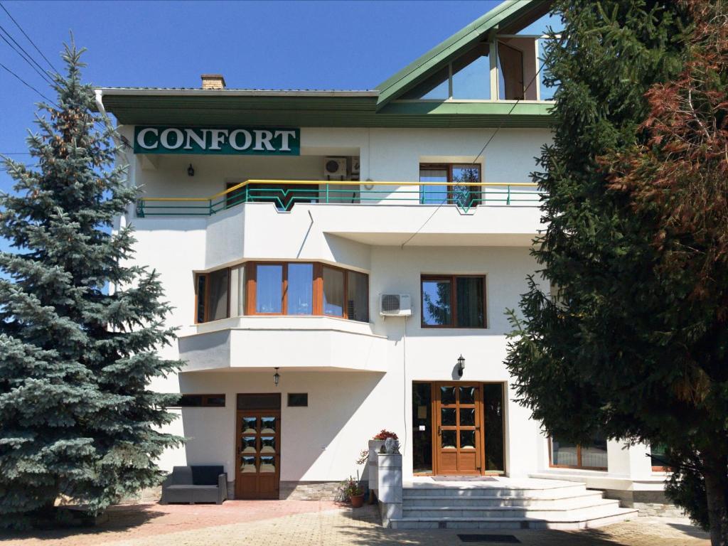 a white building with a sign that reads comfort at Pensiunea Confort in Suceava