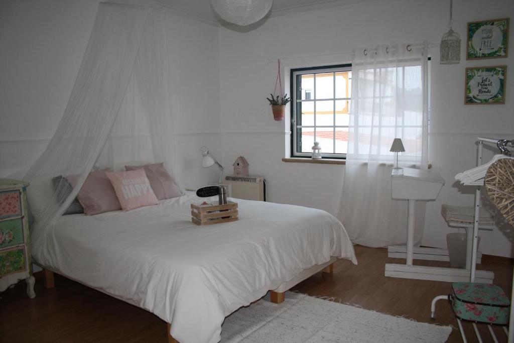 a bedroom with a white bed with a canopy at Casa de férias Josefa D´Óbidos in Óbidos
