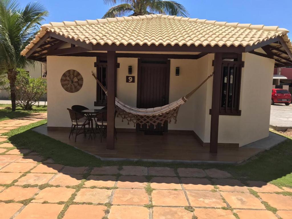 ein kleines Haus mit einer Hängematte davor in der Unterkunft Chale Mamelucos em Frente A Praia de Ipitanga Salvador Bahia in Salvador