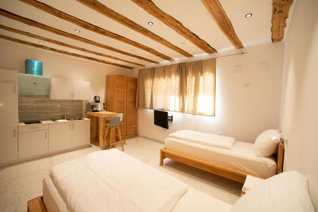 sala de estar con 2 camas y cocina en GarDar Studio Fox, en Bolzano