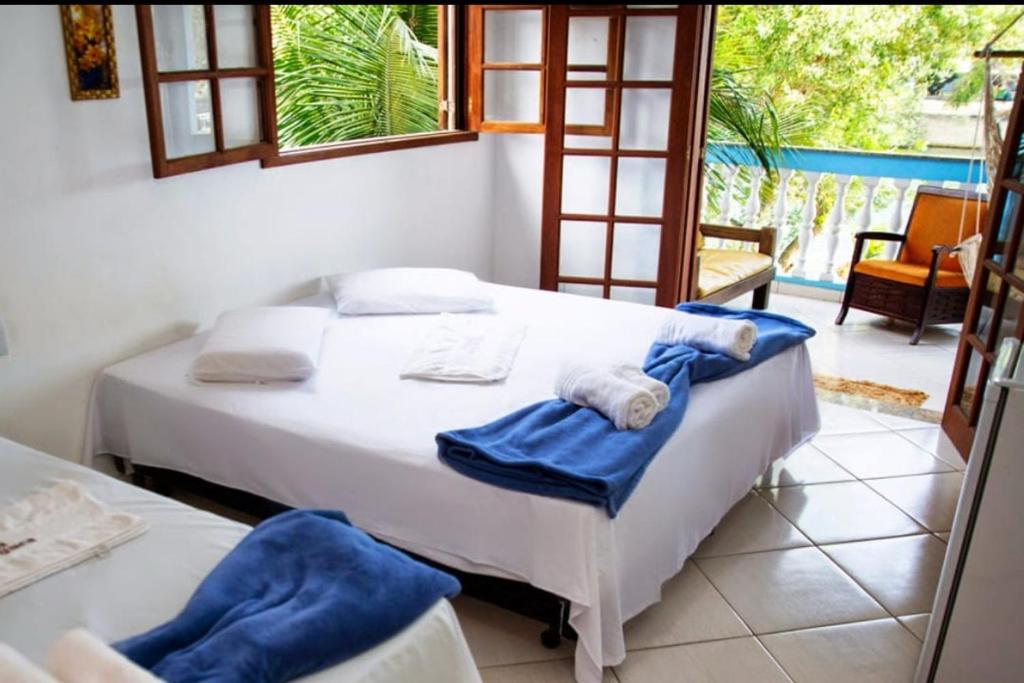 a bedroom with two beds with towels on them at Pousada Barra da Tijuca in Rio de Janeiro