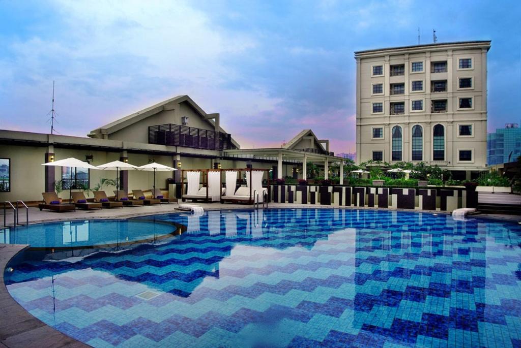 a large swimming pool in front of a building at Grand City Hall Hotel & Serviced Residences in Medan