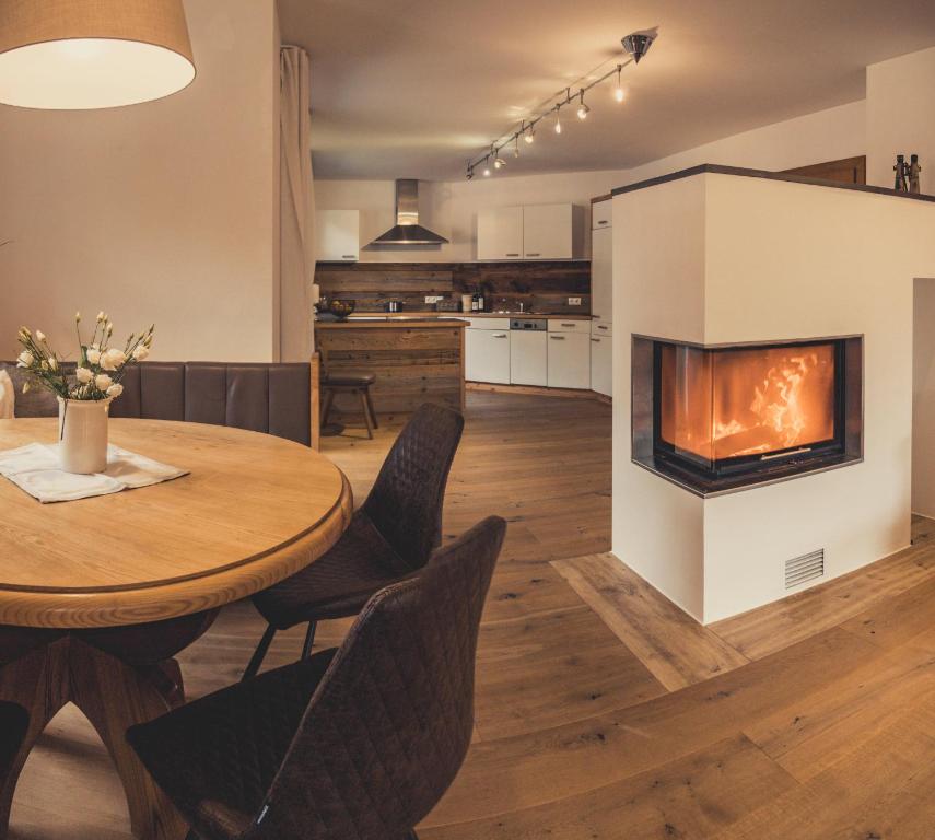 ein Wohnzimmer mit einem Tisch und einem Kamin in der Unterkunft Postwirt Annaberg in Annaberg im Lammertal