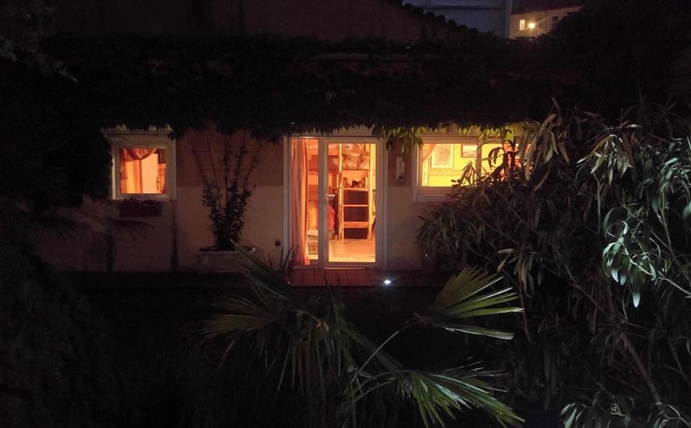 a small house with a red door at night at Le Relais de Montchat in Lyon