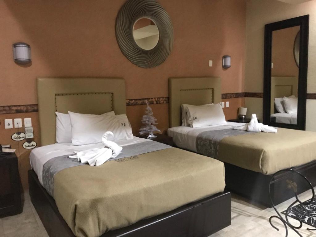 twee bedden in een hotelkamer met handdoeken erop bij Villas y Suites Paraiso del Sur in Cuernavaca