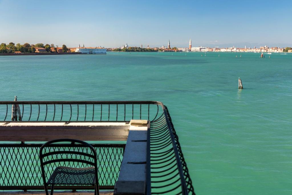 a bench sitting on a pier next to the water at Hotel Villa Laguna in Venice-Lido