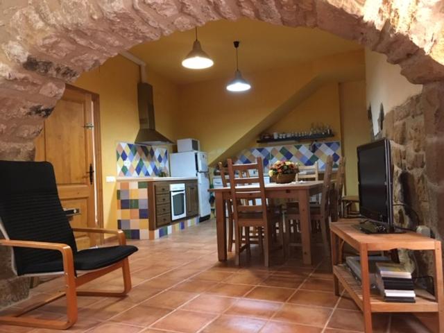 uma sala de estar com uma mesa e uma cozinha em Cal Cabrer - El Vilosell em El Vilosell