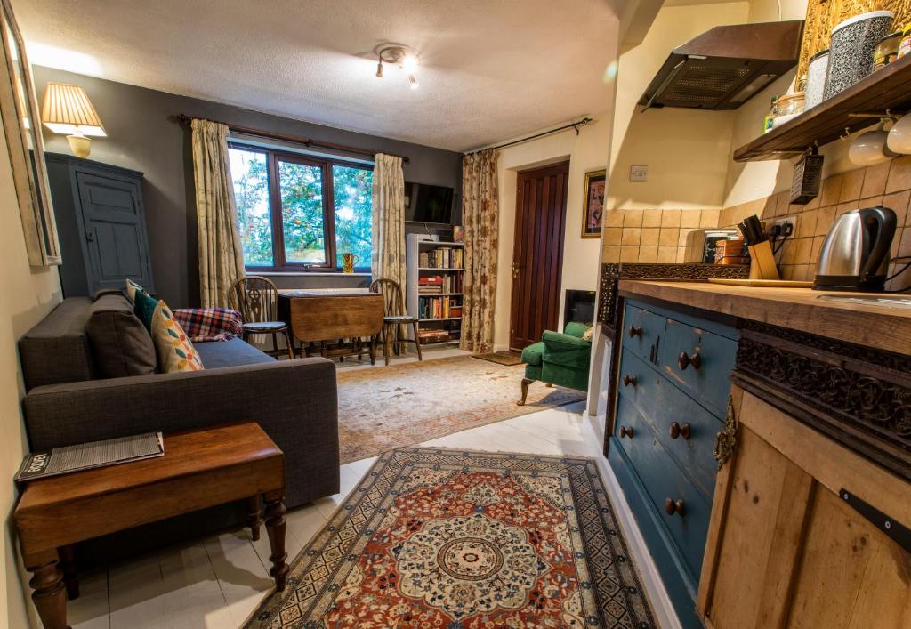Dilkara Apartment Glastonbury في غلاستونبري: مطبخ وغرفة معيشة مع أريكة وطاولة