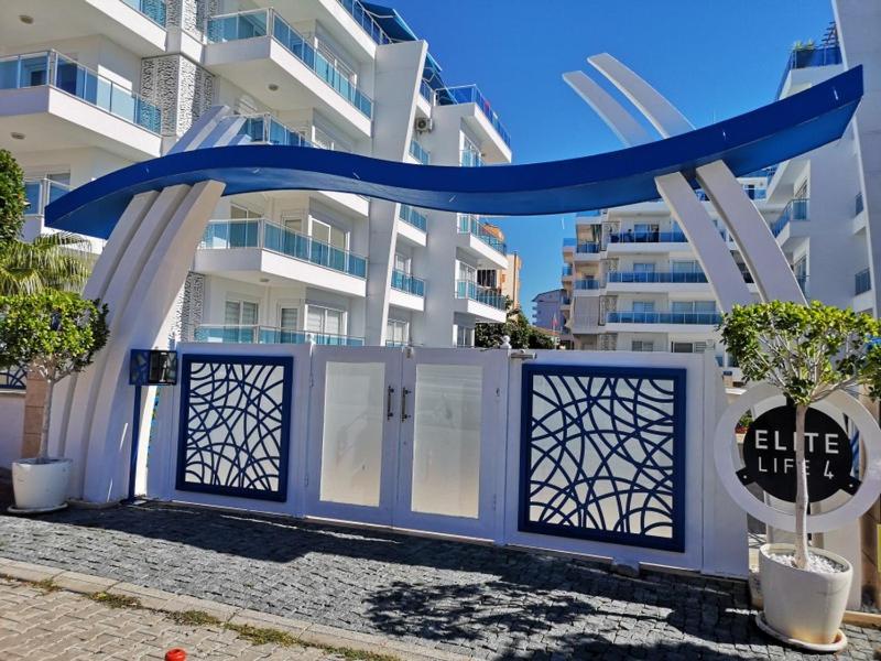 um portão azul em frente a um edifício branco em Elite Life Residence 4 em Avsallar
