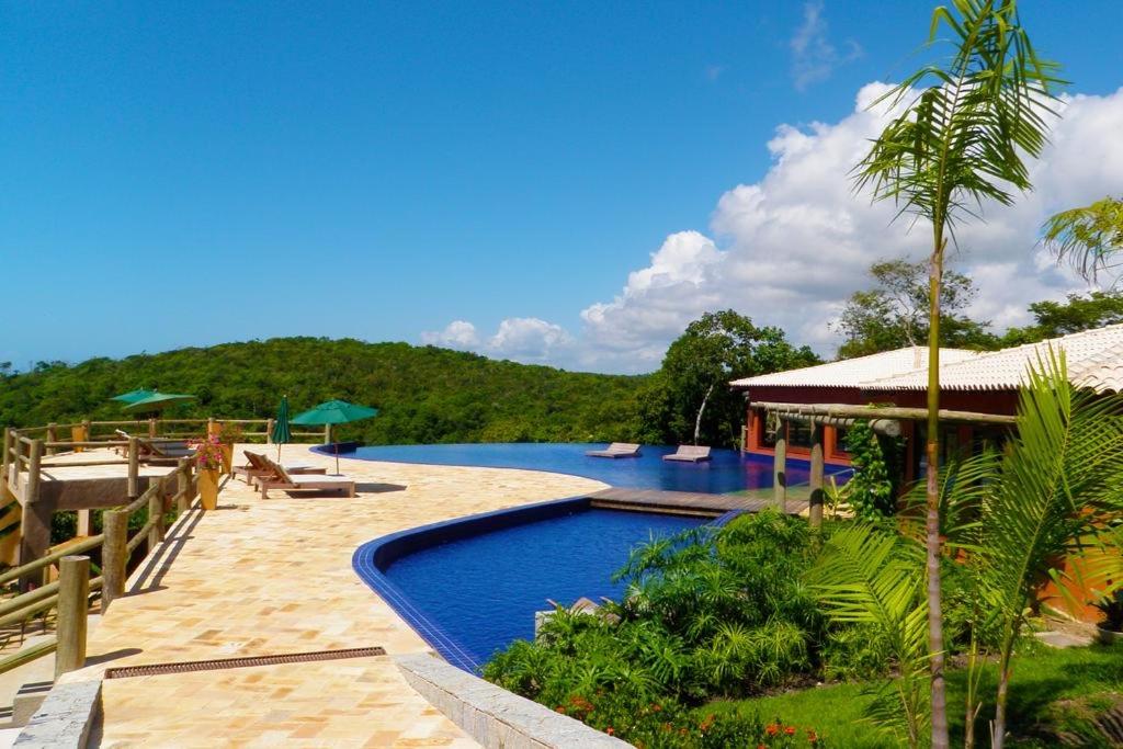 a resort with a swimming pool with a mountain in the background at Villas do Pratagy - Pitanga B3 in Maceió