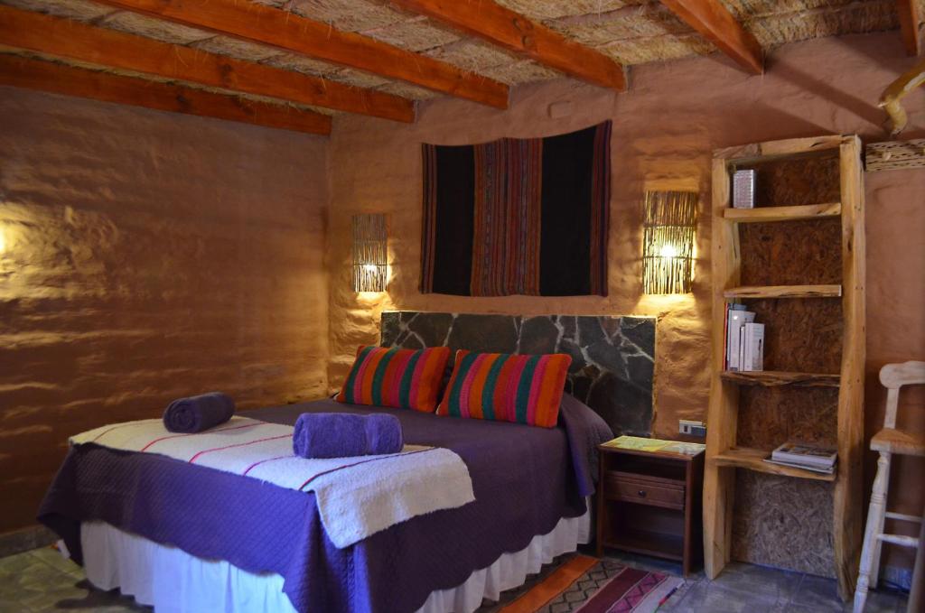 a bedroom with a bed and a book shelf at Ckuri Atacama in San Pedro de Atacama
