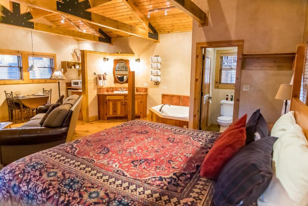 a bedroom with a large bed and a bathroom at Riverside Cottage #26 in Ruidoso