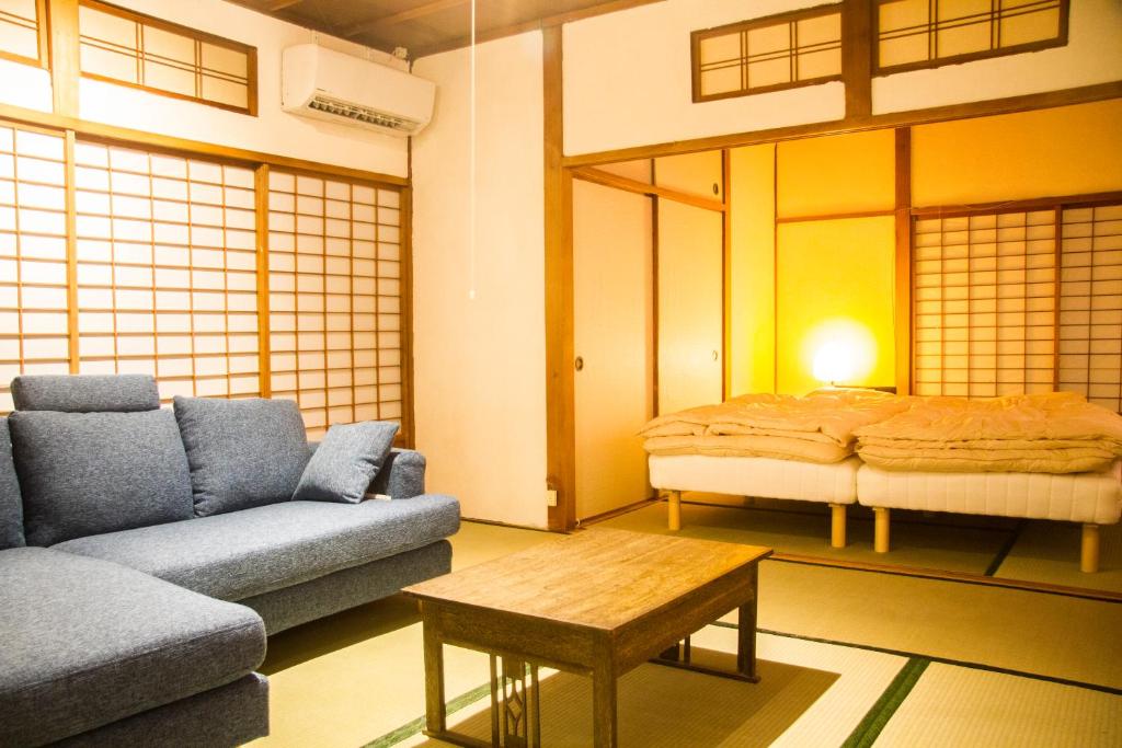 - un salon avec un canapé et un lit dans l'établissement Engawa, à Tonosho