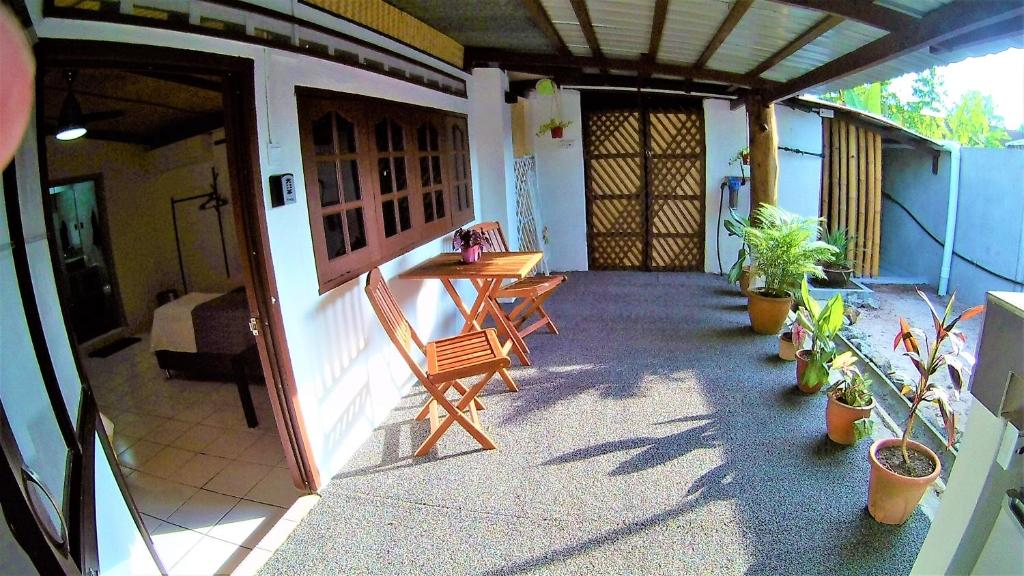 a porch with a table and chairs and potted plants at Sabandy Guesthouse in Kuah