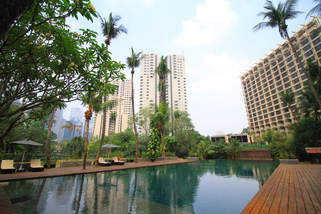 
a large body of water surrounded by palm trees at The Sultan Hotel & Residence Jakarta in Jakarta
