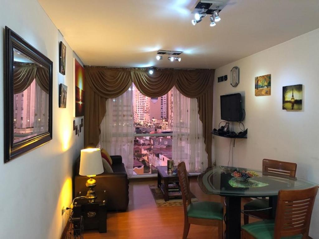 sala de estar con mesa y vistas a la ciudad en A Perfect Vacation Getaway Apartment, en Lima