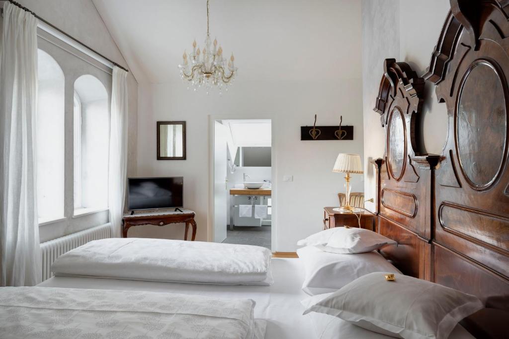 a bedroom with two beds and a chandelier at Villa Bergmann Suites Meran in Merano