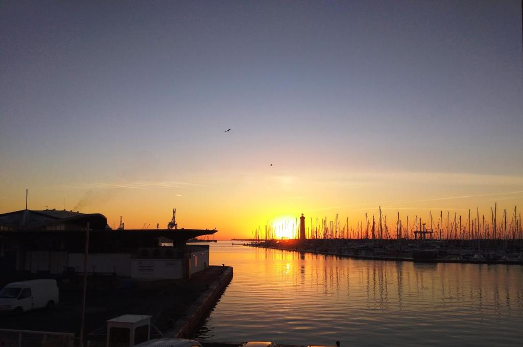 un coucher de soleil sur une étendue d'eau avec des bateaux dans l'établissement Le Love Appartement, à Sète