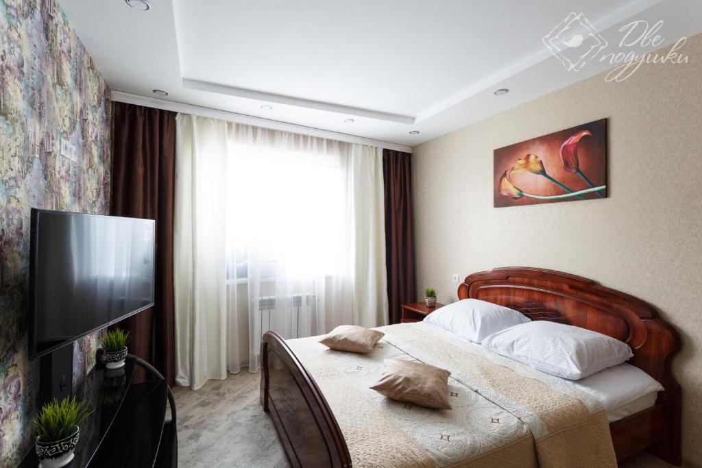 ヴォログダにあるApartment 2Pillows on Gagarinaのベッドとテレビが備わるホテルルームです。