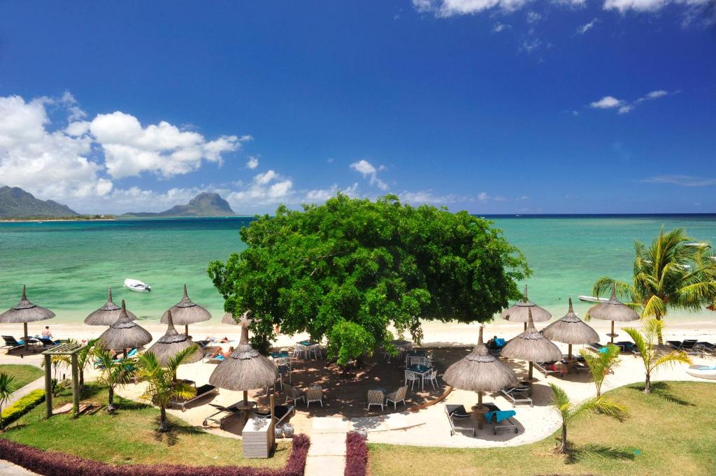 Blick auf einen Strand mit Sonnenschirmen und das Meer in der Unterkunft La Mariposa Mauritius in Rivière Noire