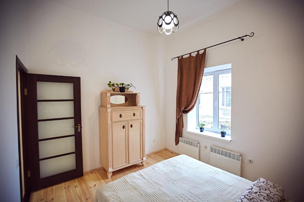 een slaapkamer met een bed en een raam bij Babylon Apartments On Dubenska Street in Rivne