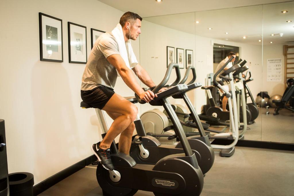 a man riding on an exercise bike in a gym at The Principal Madrid, Small Luxury Hotels in Madrid
