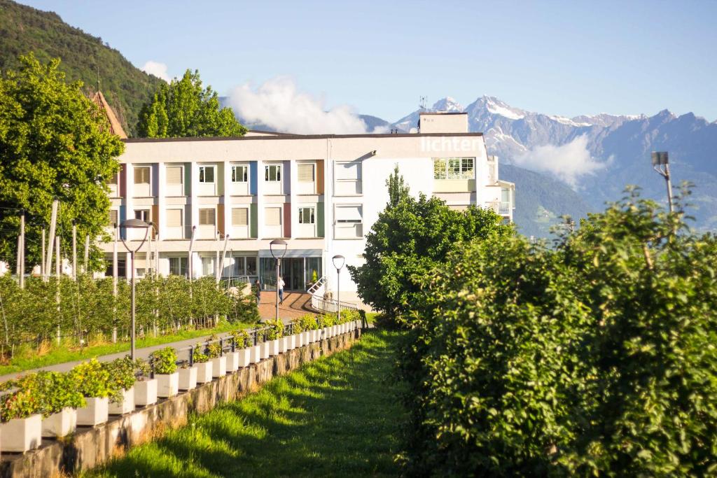 a building with a row of trees in front of it at Pension Lichtenburg in Nalles