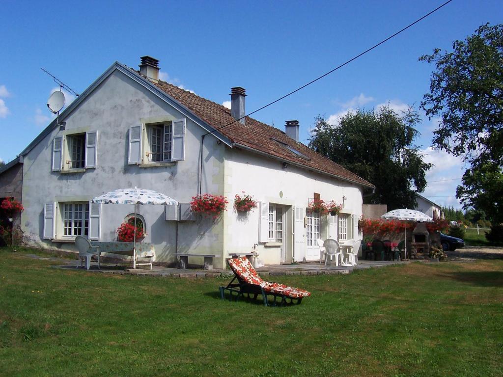 una casa blanca con un banco delante en Gîtes La Coquille, en Ternuay-Melay-et-Saint-Hilaire