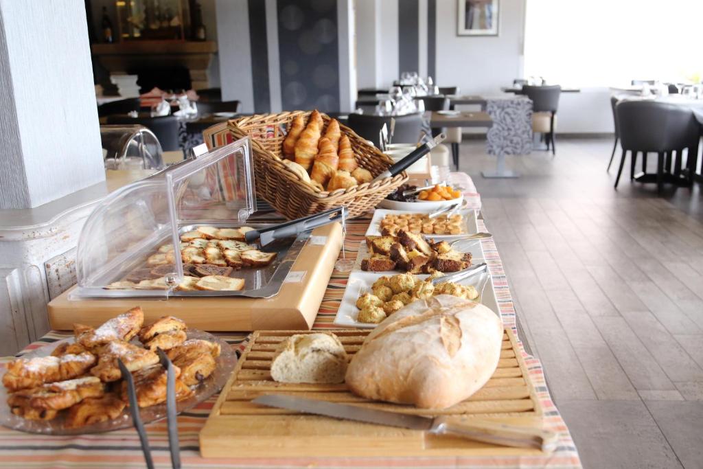 a table with various types of bread and pastries at Hostellerie De La Mer in Crozon