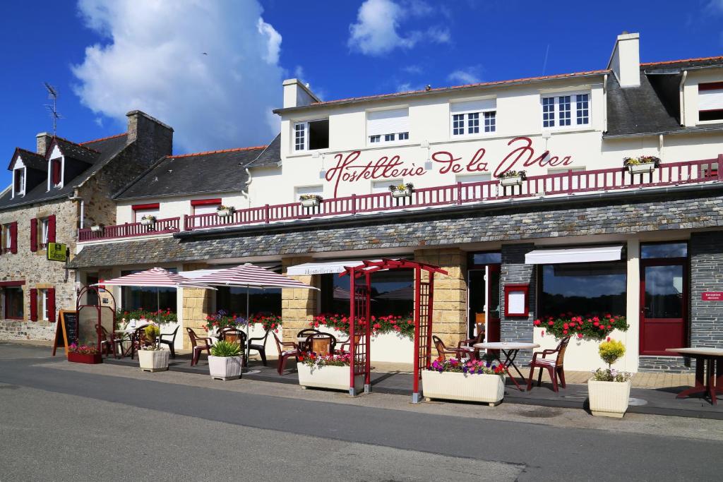 a building with tables and chairs on a street at Hostellerie De La Mer in Crozon