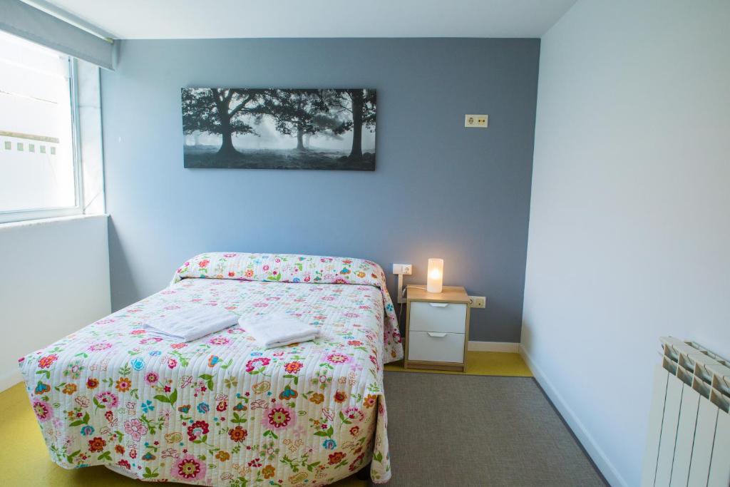 um quarto com uma cama e uma mesa com uma vela em casa albergue picota em Mazaricos