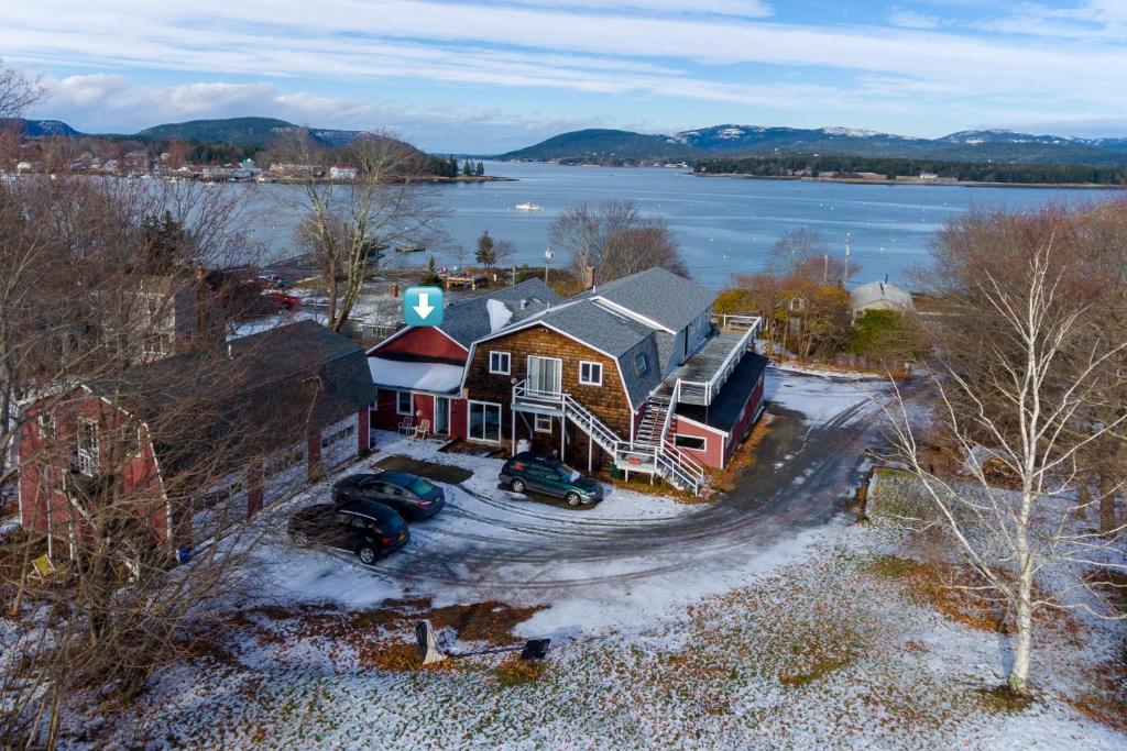 an aerial view of a house with snow and water at Manset Grotto in Southwest Harbor