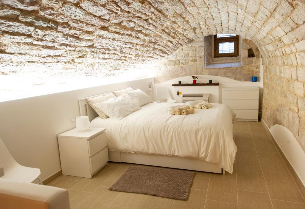 um quarto com uma cama e uma parede de pedra em Gino's house in Old Town.. em Gubbio