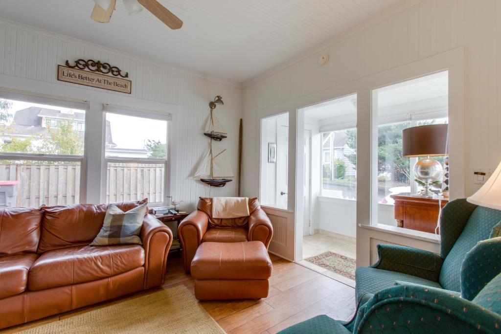 a living room with a couch and chairs and windows at Seaside Cottage in Seaside