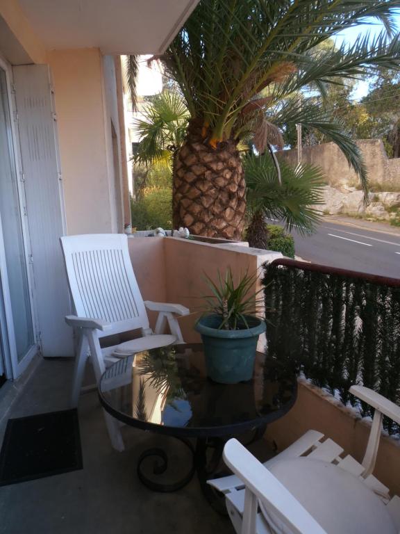 a porch with two chairs and a table and a pineapple at Cosy Nîmes in Nîmes