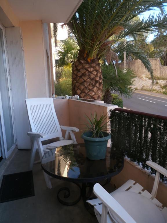 een veranda met 2 stoelen, een tafel en een ananas bij Cosy Nîmes in Nîmes