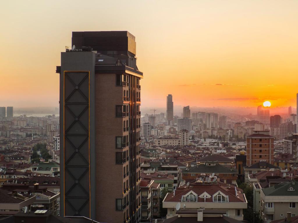 a tall building with the sunset in the background at Cityloft 161 in Istanbul