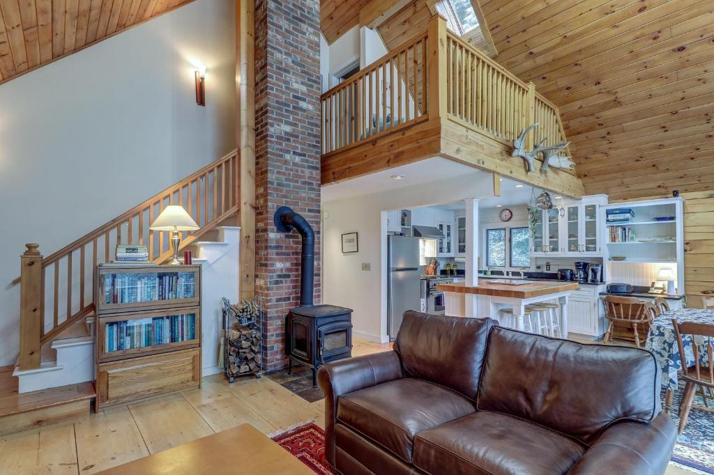 a living room with a leather couch and a kitchen at River Ridge Rendezvous in Morrisville