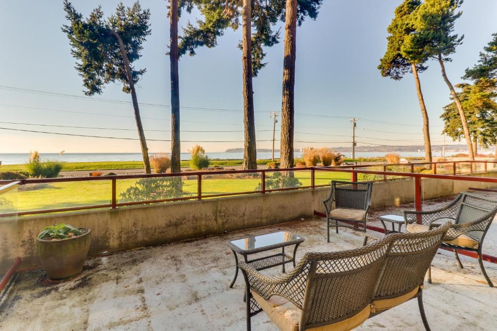 a patio with chairs and tables and palm trees at Birch Bay Sunset View in Bellingham