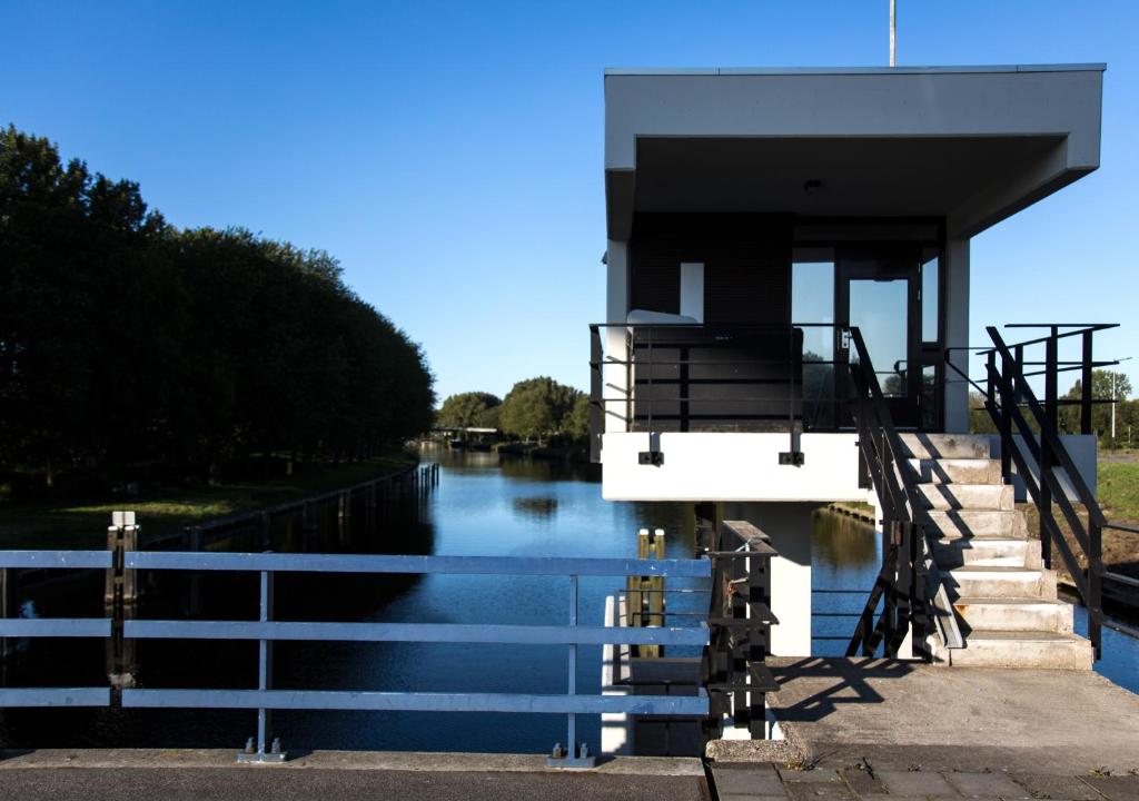 a house on a river with stairs on it at SWEETS - Meeuwenpleinbrug in Amsterdam