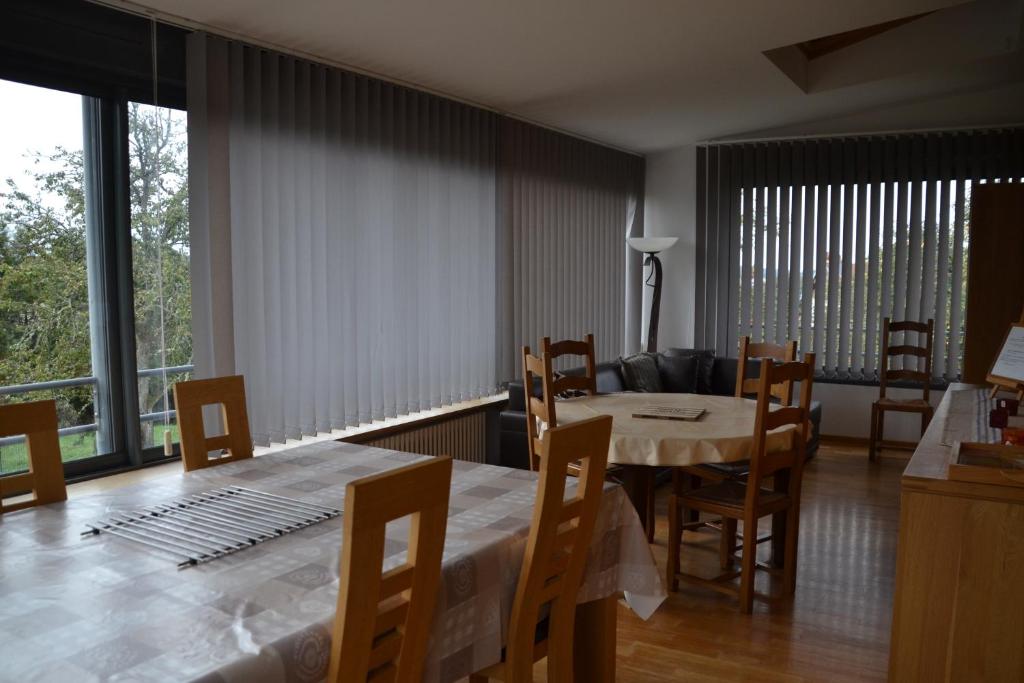 a dining room with a table and chairs and a living room at Gîte "Chez Paul" in Épinal