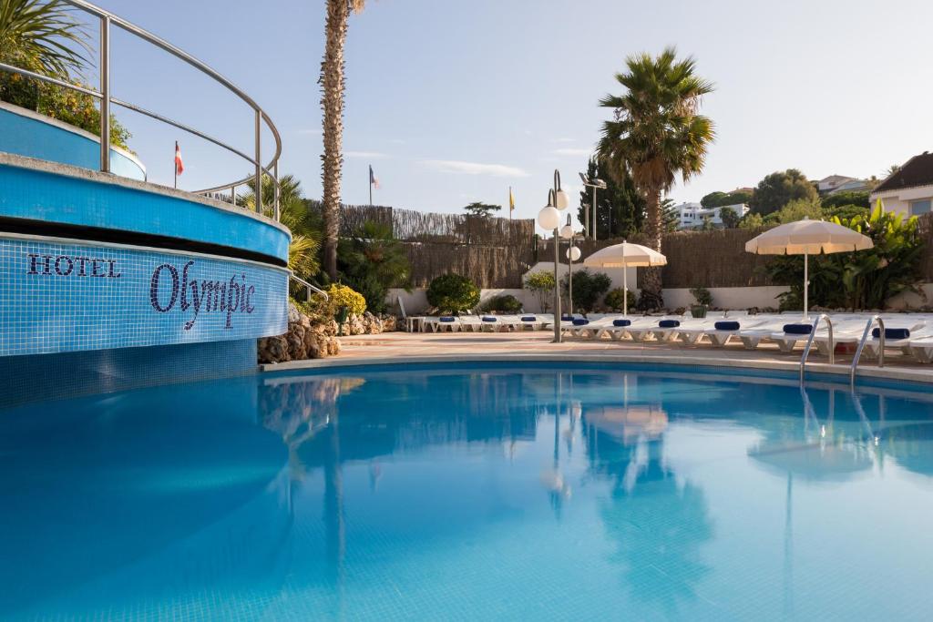 een zwembad in een hotel met stoelen en parasols bij htop Olympic #htopEnjoy in Calella