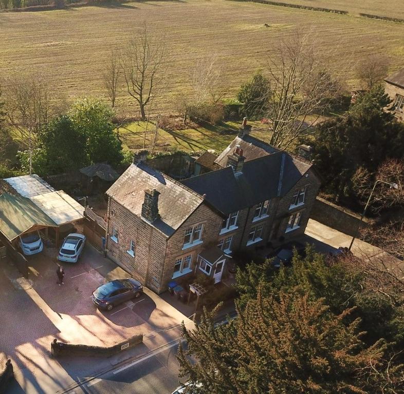 una vista aérea de una casa grande con coches aparcados en un aparcamiento en Slayleigh B&B, Matlock, en Matlock